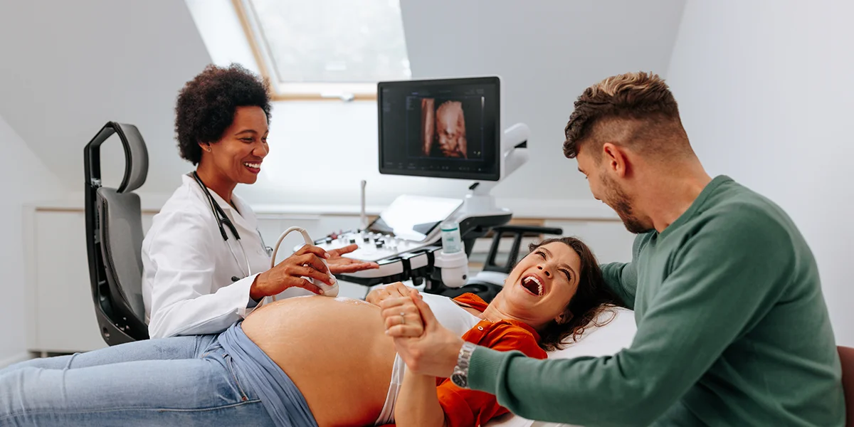 Pregnant couple smiling during an ultrasound