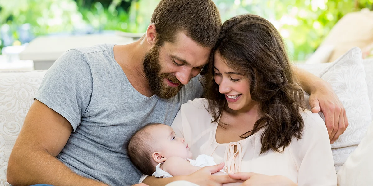 Beautiful young caucasian couple holding their new baby