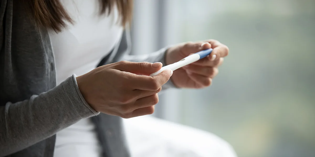 Woman’s hands holding a pregnancy test