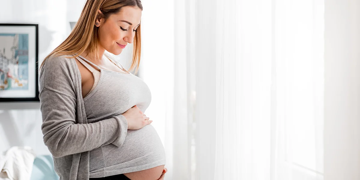 Young caucasian woman holding her pregnant belly