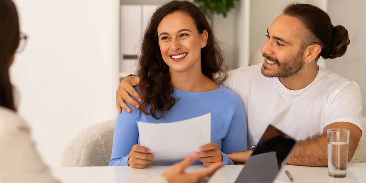 Happy young couple talking to an egg donation specialist