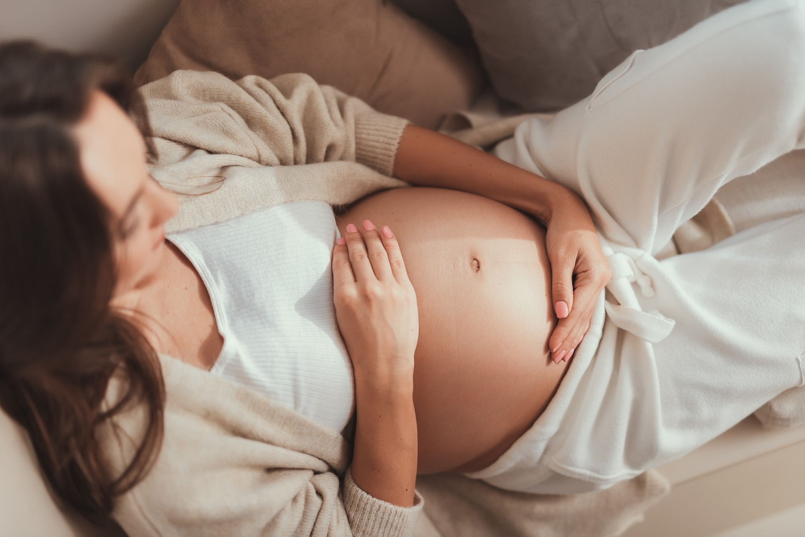 Young caucasian woman holding her pregnant belly