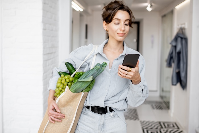 Young caucasian woman bringing healthy groceries home