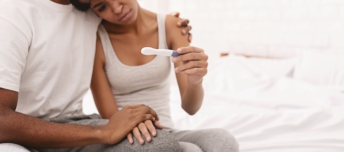 Black couple sad about a negative pregnancy test