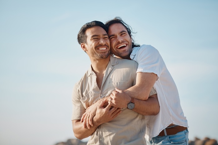 Gay couple hugging in the sunshine