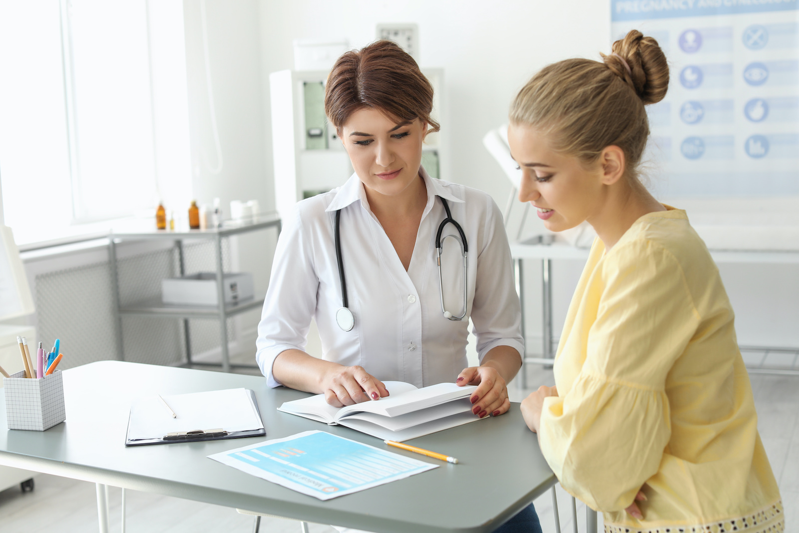 Young woman sitting in a medical office, talking to a doctor