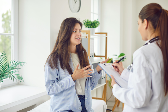 Young brunette woman talking to her doctor in an office.