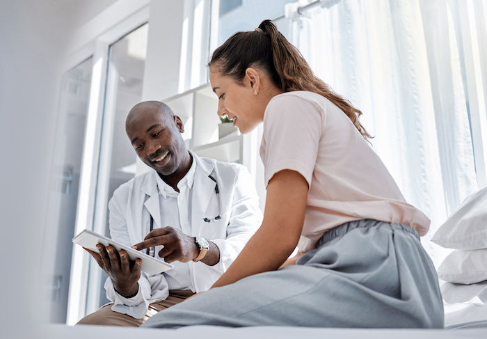 Black male doctor talking to a female patient.