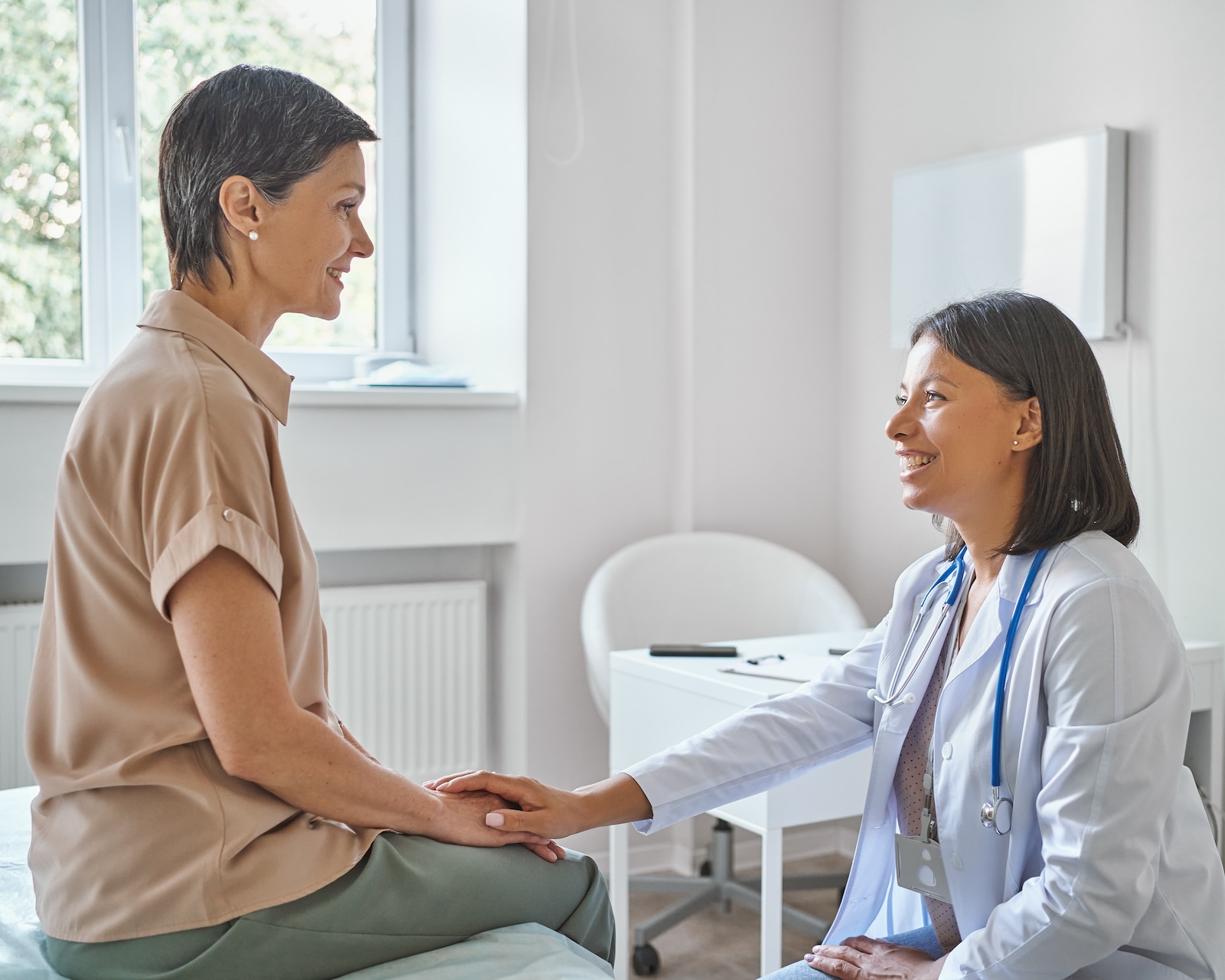 Middle-aged blonde woman talking to a female medical professional