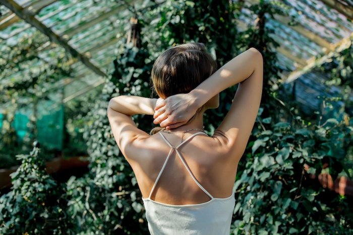 Young woman inside a greenhouse filled with ivy