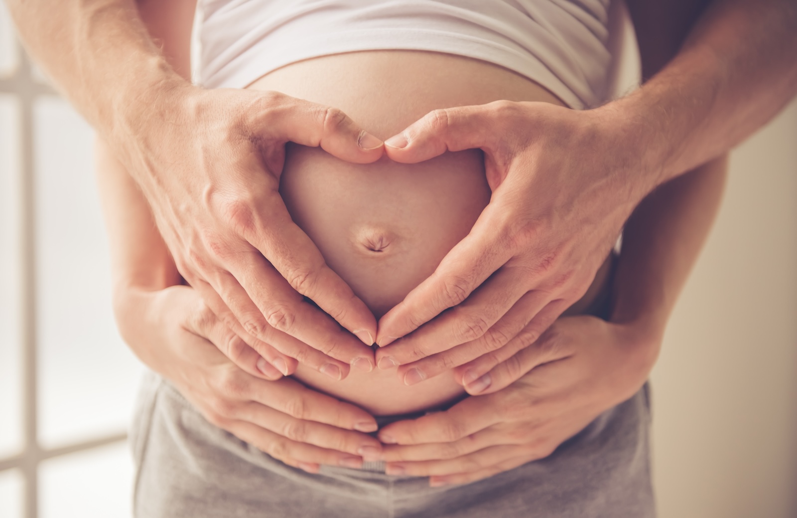 Couple holding their pregnant belly
