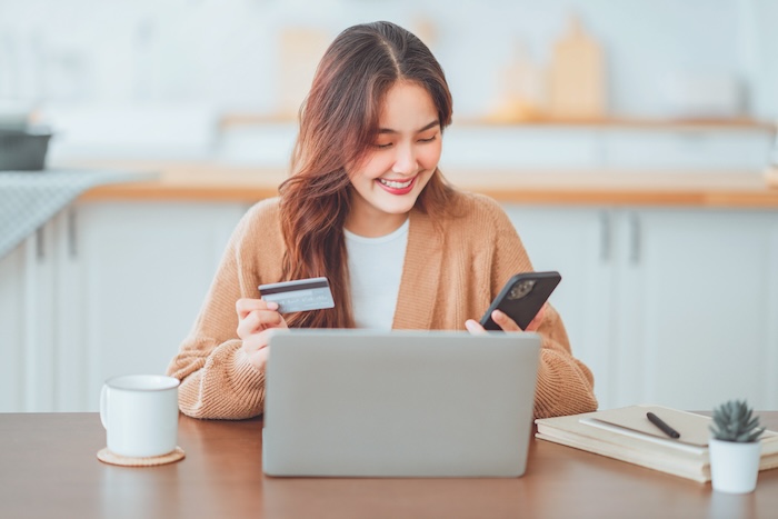 Young asian woman checking her account balance at home