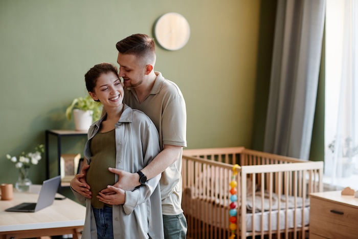 Young caucasian couple preparing their nursery for their baby’s arrival