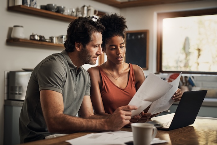 Mixed race couple researching egg donation at home. 